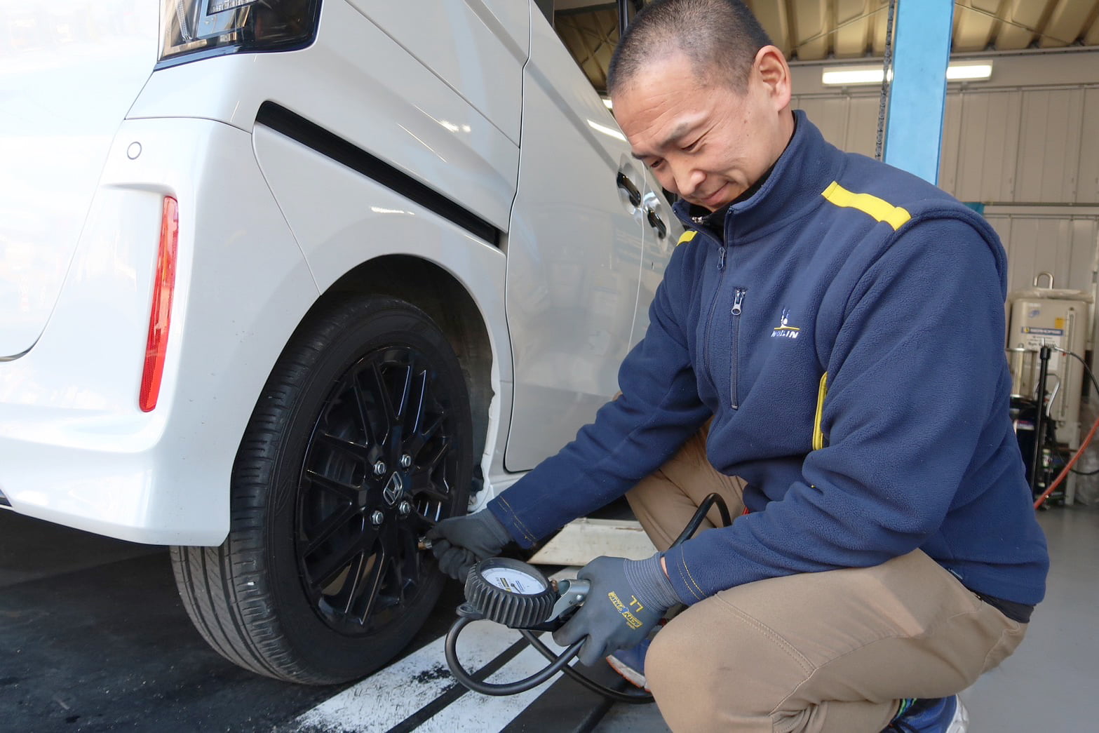 タイヤの空気圧点検をする代表・井上